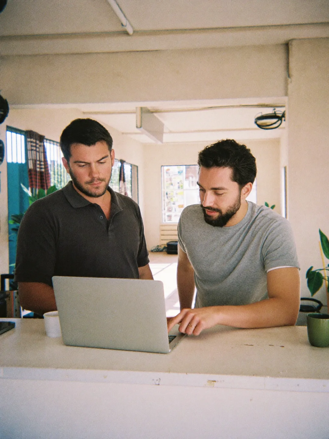 Dono da academia e professor revisando um treino no notebook da recepção